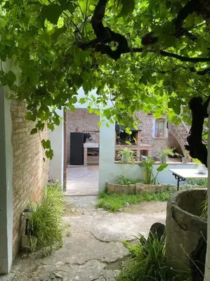 a garden with a table and a kitchen in a building at Ca la Trini - turisme rural in Torrellas de Foix