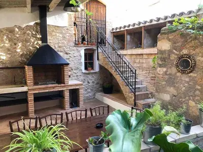 a patio with a staircase and a table and chairs at Ca la Trini - turisme rural in Torrellas de Foix