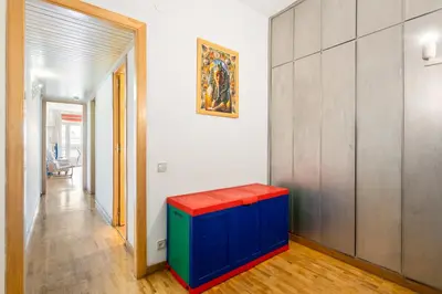 a colorful stool in a hallway with a painting on the wall at Families & Groups 4BR2BA by Sagrada in Barcelona
