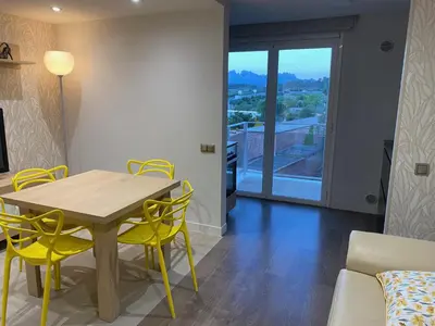 a dining room with a table and yellow chairs at Apartament Sant Jordi in Sant Joan de Vilatorrada