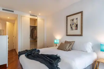 a bedroom with a white bed and a mirror at Canela Homes BARCELONA DIAGONAL MAR in Barcelona
