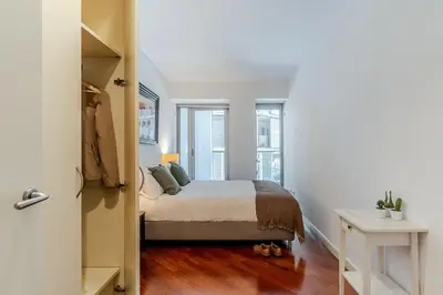a bedroom with a bed and a table and windows at Canela Homes BARCELONA DIAGONAL MAR in Barcelona