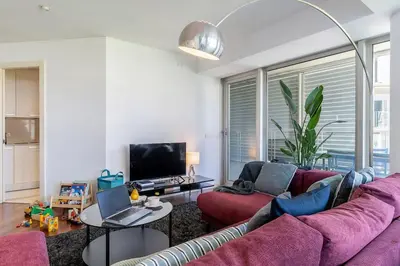 a living room with a purple couch and a tv at Canela Homes BARCELONA DIAGONAL MAR in Barcelona