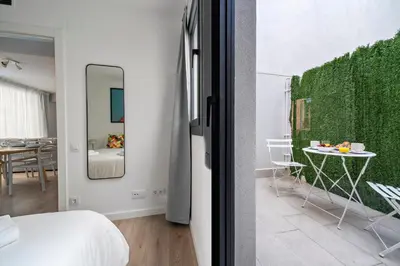 a bedroom with a bed and a table with a mirror at Habitat Apartments Teatre in Hospitalet de Llobregat