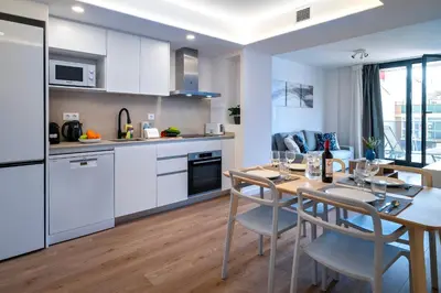 a kitchen and dining room with a table and chairs at Habitat Apartments Teatre in Hospitalet de Llobregat