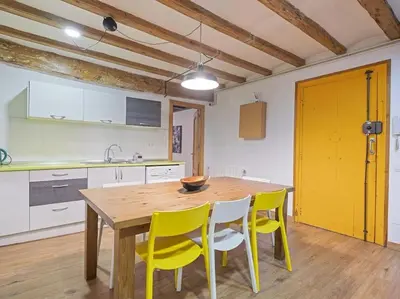 a kitchen with a wooden table and yellow chairs at Las Ramblas, comfort in BCN for 8 persons in Barcelona