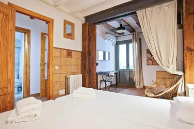 a bedroom with two beds and a living room at Las Ramblas, comfort in BCN for 8 persons in Barcelona