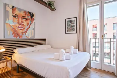 a bedroom with a bed and a large window at Heaven With a Garden at Las Ramblas in Barcelona