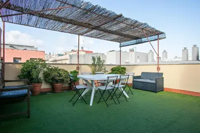 a patio with a table and chairs on a roof at Heaven With a Garden at Las Ramblas in Barcelona