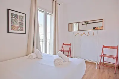 a bedroom with a bed and two chairs and a window at Heaven With a Garden at Las Ramblas in Barcelona