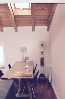 a dining room with a wooden table and a fan at CasaOller in Manresa