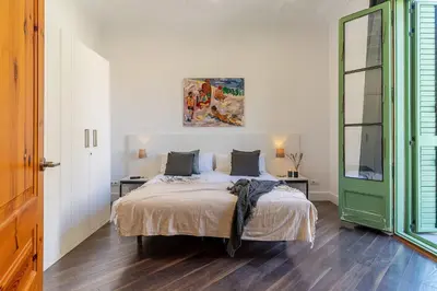 a bedroom with a bed and a green door at Canela Homes BARCELONA FAMILY in Barcelona