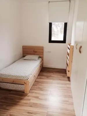 a small bedroom with two beds and a window at Casa Natura Montseny in El Brull