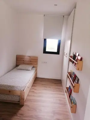 a small bedroom with a bed and a window at Casa Natura Montseny in El Brull