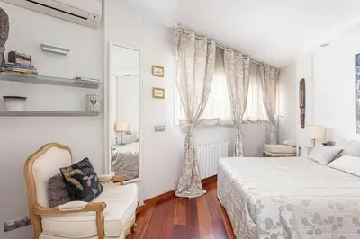 a white bedroom with a bed and a window at Canela Homes BARCELONA OLYMPIC in Barcelona