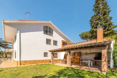 a large white house with a patio and a backyard at Large 5-Bed Villa, mountain and beach, at 30' from Barcelona & 10' from F1 Circuit in Vallromanas