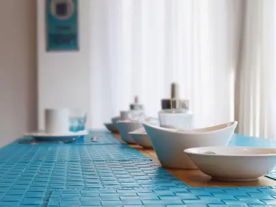 a row of bowls sitting on a blue tiled counter at Blue Barcelona in Barcelona