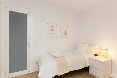 a bedroom with a white bed and a mirror at Suites Barcelona Park Güell in Barcelona