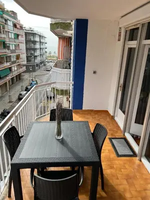 a table with chairs and a vase on a balcony at Logement avec vue latérale mer in Pineda de Mar