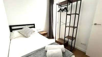 a bedroom with a white bed and a book shelf at Centro con terraza blco by Prestigi in Terrassa
