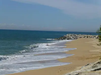 a beach with rocks and the ocean on a sunny day at Apartment La Rosa (Blaumar) in Sant Andreu de Llavaneres