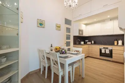 a kitchen with a white dining room table and chairs at Sagrada Familia Apartment in Barcelona