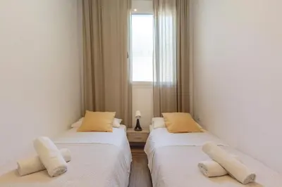 two twin beds in a room with a window at Sagrada Familia Apartment in Barcelona