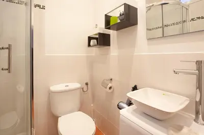 a white bathroom with a toilet and a sink at Sagrada Familia Apartment in Barcelona