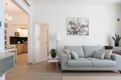 a living room with a couch and a kitchen at Sagrada Familia Apartment in Barcelona