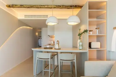 a kitchen with a counter and stools in a room at Apartamentos Azul in Castelldefels