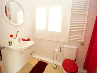 a white bathroom with a red toilet and a sink at The Villa Sunlight in Sitges
