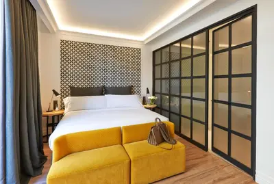 a bedroom with a large bed and a yellow couch at Serras Barcelona in Barcelona