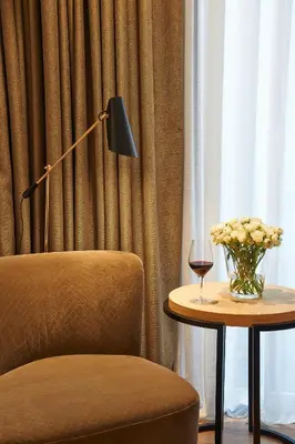 a chair and a table with a vase of flowers and a lamp at Serras Barcelona in Barcelona
