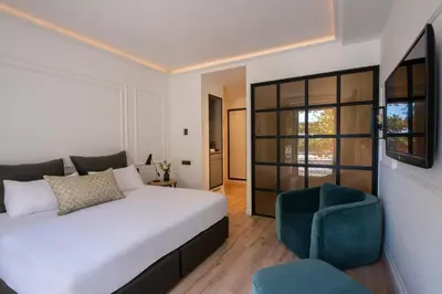 a bedroom with a white bed and a blue chair at Serras Barcelona in Barcelona