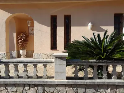 a porch of a house with a fence and plants at Villa Antonia in Mataró