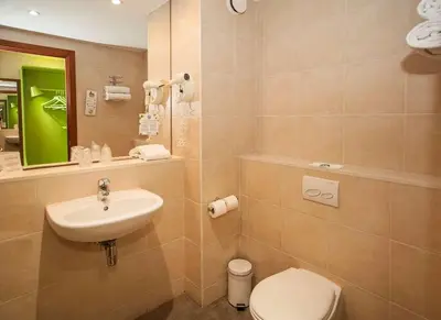 a bathroom with a sink and a toilet and a mirror at Travelodge BCN Cornella Fira in Cornellà de Llobregat