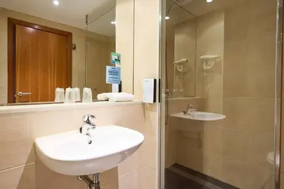 a bathroom with a sink and a mirror at Travelodge BCN Cornella Fira in Cornellà de Llobregat