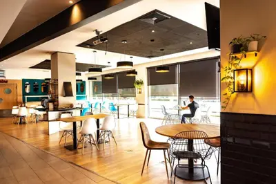 a person sitting at a table in a restaurant at Travelodge BCN Cornella Fira in Cornellà de Llobregat