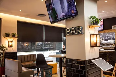 a bar with a flat screen tv on the wall at Travelodge BCN Cornella Fira in Cornellà de Llobregat