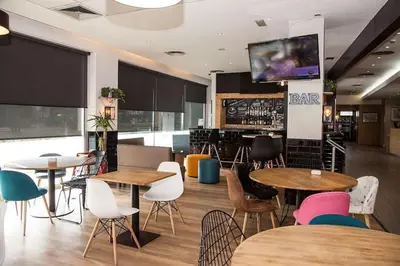 a restaurant with tables and chairs and a bar at Travelodge BCN Cornella Fira in Cornellà de Llobregat