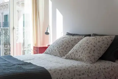 a bed with two pillows in a bedroom with a window at Central Verdete in Barcelona