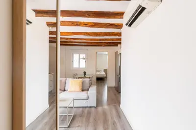 a living room with a white couch and a mirror at Decô Apartments Barcelona-Sants in Barcelona