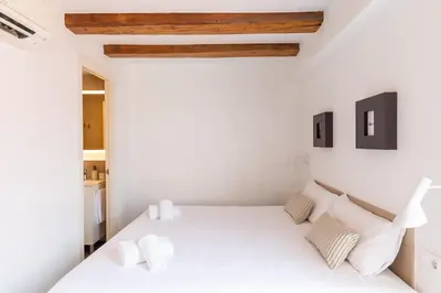 a white bedroom with a white bed with white pillows at Decô Apartments Barcelona-Sants in Barcelona