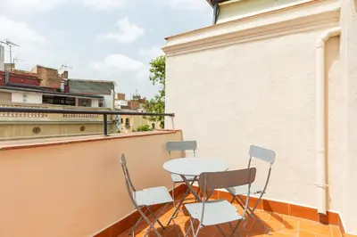 a balcony with a table and chairs on a building at Decô Apartments Barcelona-Sants in Barcelona