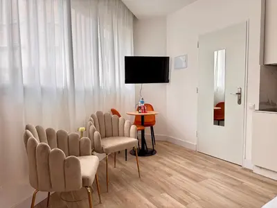 a room with chairs and a table and a tv at Crysoyle Apartment II Barcelona Next to Camp Nou in Hospitalet de Llobregat