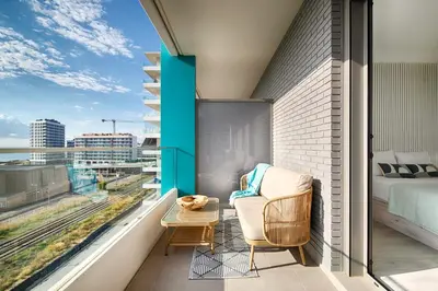 a balcony with a bed and a chair and a table at Seaside Badalona Apartment in Badalona