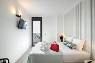 a bedroom with a bed with a red bag on it at Seaside Badalona Apartment in Badalona
