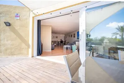 a sliding glass door to a patio with a dining room at Casa Mar Blava con piscina comunitaria junto Barcelona Centro in Alella