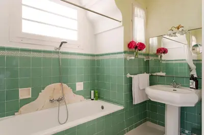 a green tiled bathroom with a sink and a bath tub at Casa Victor Riu in Piera