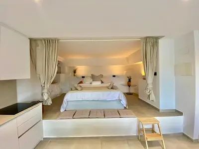 a large white bedroom with a large bed with curtains at Pandi's Place in Sant Pere de Ribes